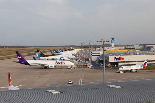 Cologne, Germany - April 08, 2018. Cargo Terminal of Cologne Bonn International Airport (CGN). A row of different Cargo airplanes from FedEx, Egypt, UPS, DHL and Maersk waiting for service at the Cargo Terminals. Lufthansa/Eurowings Airbus at the right side.
