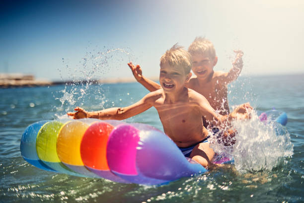 istock Kids floating on air bed on sea 950602762
