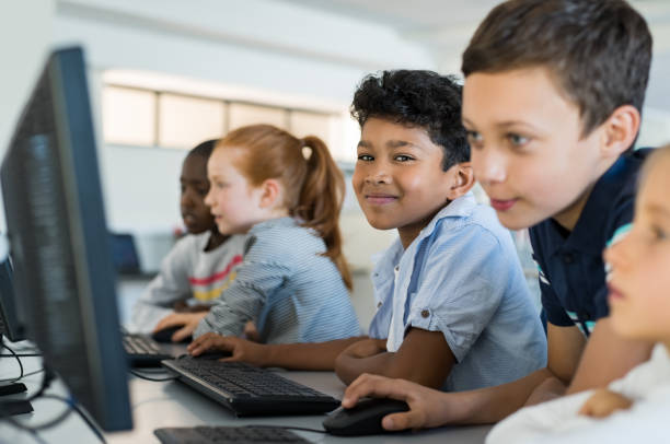 enfants qui utilisent l’ordinateur à l’école - elementary student little boys classroom child photos et images de collection