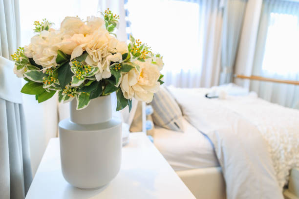 istock A bouquet of artificial flower in a pot with bed and blinds background. 950603294