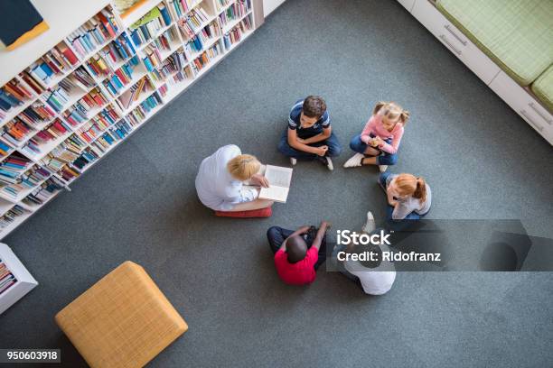 Niños Escuchando Un Cuento De Hadas Foto de stock y más banco de imágenes de Niño - Niño, Biblioteca, Educación