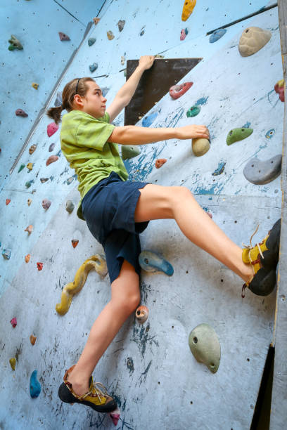 Teenage Boy Training Climbing On Indoor Climbing Wall stock photo