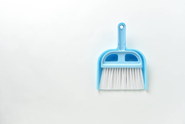 Small blue brush and scoop for cleaning the kitchen table on a white background