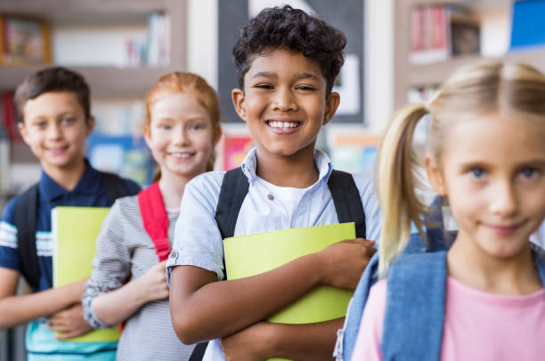 escolares de pie en una fila - niño en edad escolar fotografías e imágenes de stock