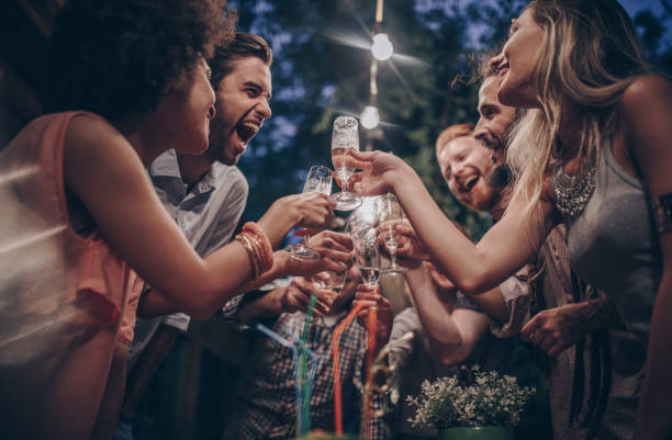 ci-dessous la vue des amis heureux, faire griller sur une partie de la nuit dans le back yard. - champagne flute champagne black wineglass photos et images de collection