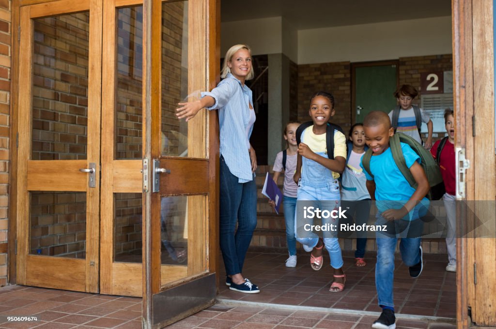 学校外を実行している小学校の子供たちのグループ - 校舎のロイヤリティフリーストックフォト