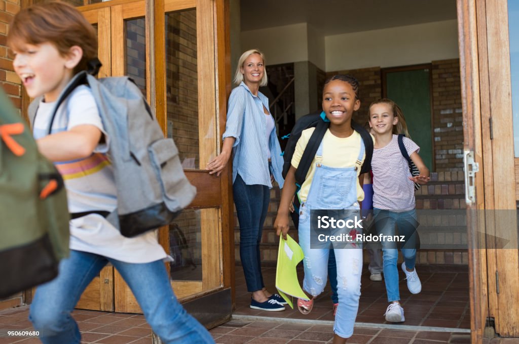 Enfants courant extérieur de l’école - Photo de Établissement scolaire libre de droits