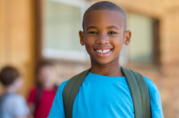 Smiling african school boy Smiling african american school boy with backpack looking at camera. Cheerful black kid wearing green backpack with a big smile. Elementary and primary school education. african american kids stock pictures, royalty-free photos & images
