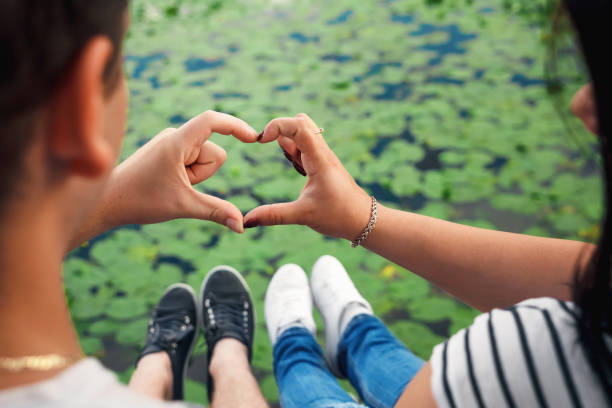 istock Closeup of couple making heart shape with hands 950612456