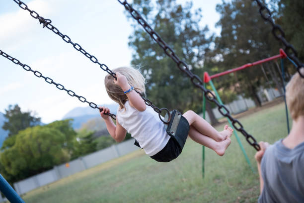 istock Swinging on the swings at the park 950613050