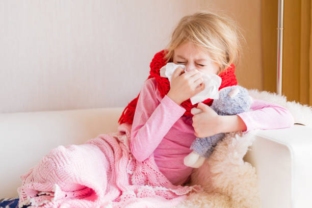istock Sick girl with runny nose sitting in sofa 950614660