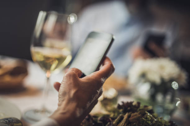 istock Close up of unrecognizable woman using mobile phone in a restaurant. 950615512