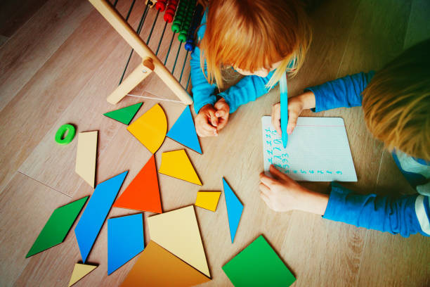 istock little boy and girl learn to write and calculate numbers 950619682