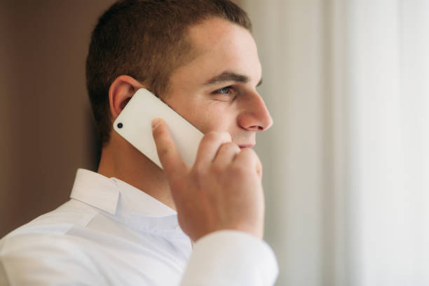 istock Handsome groom use phone in wedding day 950623304
