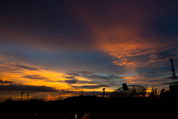 Silhouette of cellular tower with beautiful sunset cloudy sky