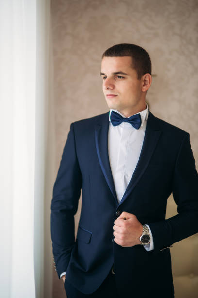 istock Handsome groom on a wedding day stand near the window 950624818