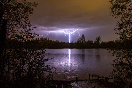Lightning bolt as summer storm passes over carp fishing lake, Marlow, England, United Kingdon