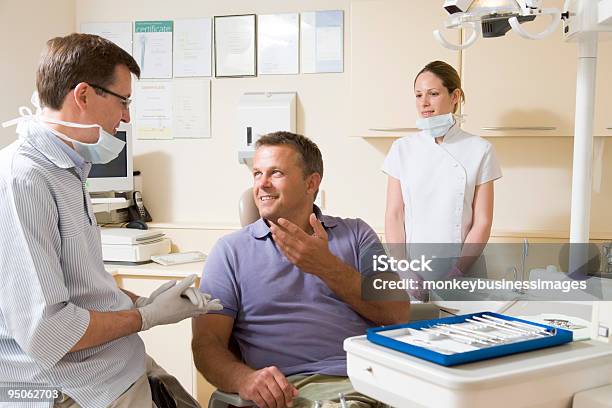 Dentist And Assistant In Exam Room With Patient Stock Photo - Download Image Now - 20-29 Years, 40-49 Years, Adult