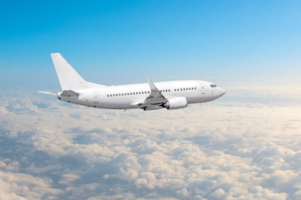 istock White airplane flies height, flight level high in the sky above the clouds blue sky. 950633258