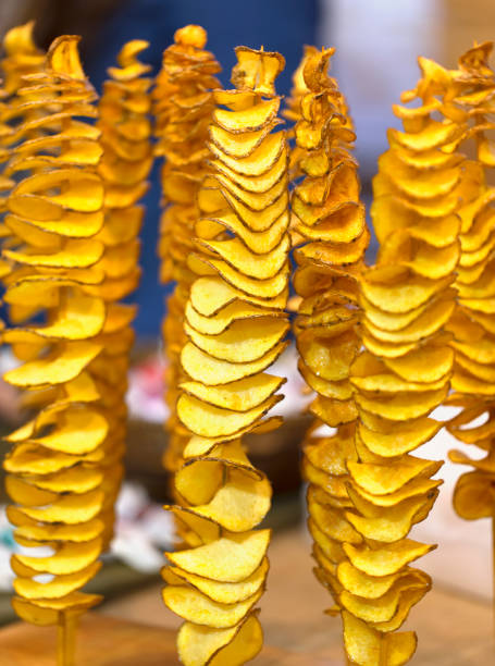 istock Spiral fried potato chips on wooden sticks. 950638246