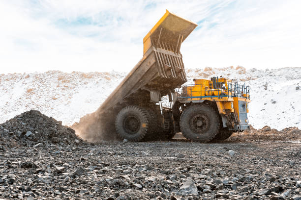 istock Large quarry dump truck. Loading the rock in dumper. Loading coal into body truck. Production useful minerals. Mining truck mining machinery, to transport coal from open-pit as the Coal Production. 950638572