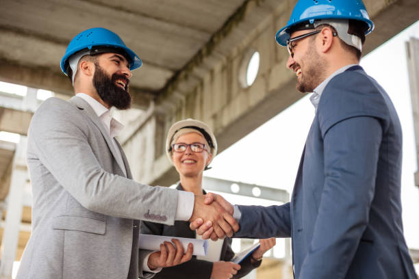 istock Two businessmen shaking hands after a successful meeting on a construction site 950639552