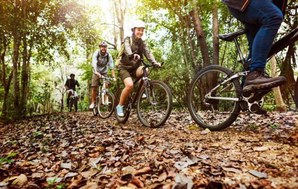 Group of friends ride mountain bike in the forest together Group of friends ride mountain bike in the forest together mountain bike stock pictures, royalty-free photos & images