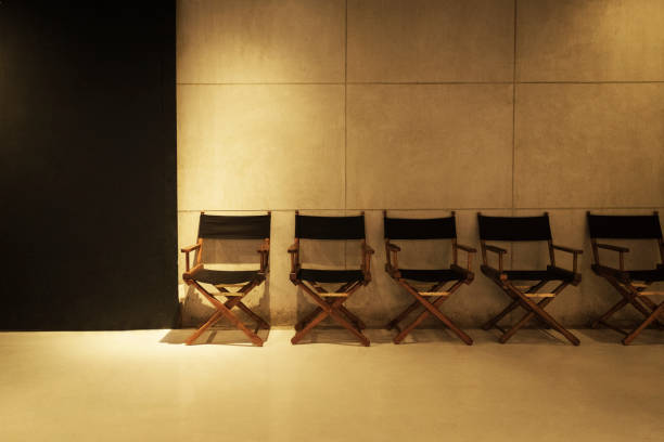 Row of director's chair on gray cement background in studio.