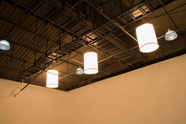istock Large lamp hanging on ceiling in studio.  Black steel roof frame sturdy. 950644296