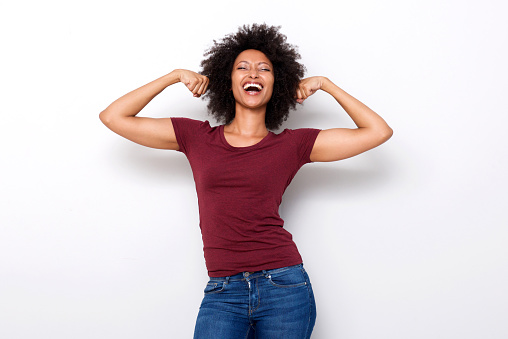 mujer africana joven sana flexionar ambos brazos músculos sobre fondo blanco photo