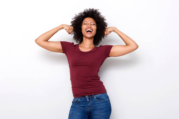 healthy young african woman flexing both arms muscles on white background