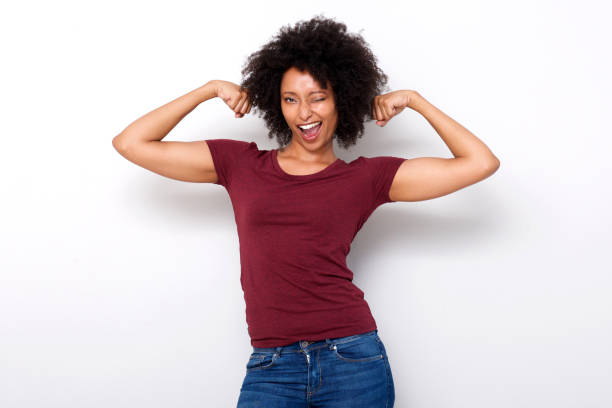 istock strong young african woman flexing both arms muscles and winking on white background 950646438