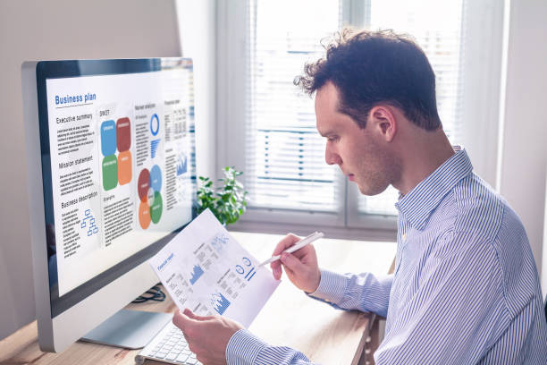 istock Businessman working on business plan on computer screen in office 950653316