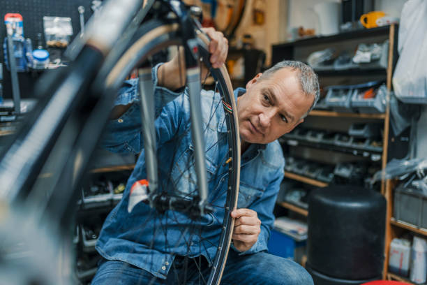 cambio neumático de la bicicleta de hombre maduro - bicycle frame fotografías e imágenes de stock