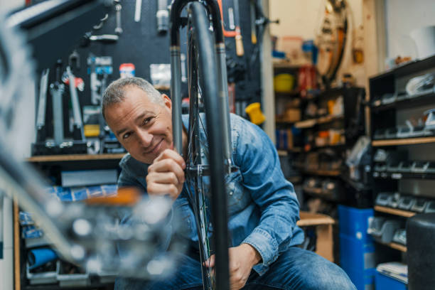 istock Repairman repairing bicycle in workshop 950664890