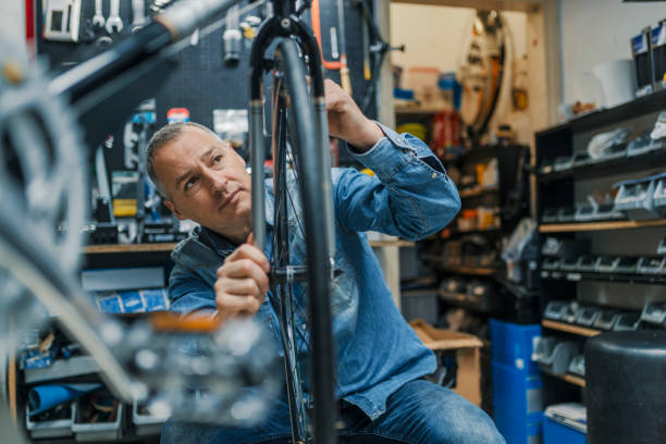 istock Bicycle mechanic carrying a bike in workshop 950665202