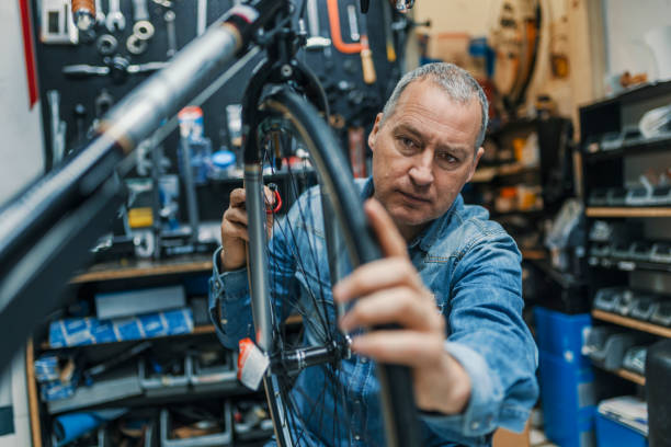 istock Bicycle mechanic carrying a bike in workshop 950665364