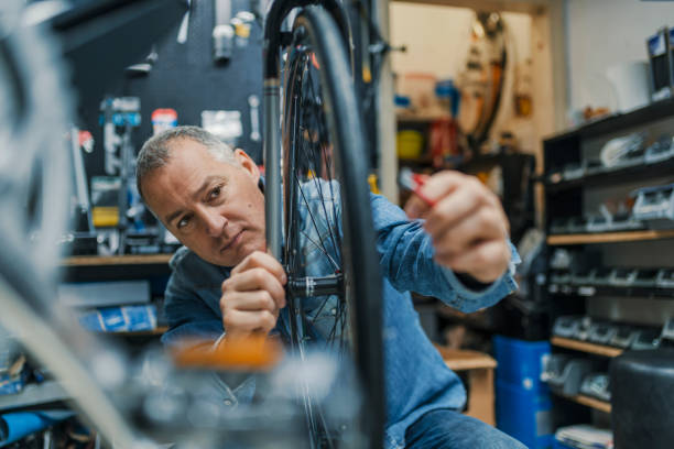 Technical expertise taking care Bicycle Shop Technical expertise taking care Bicycle Shop. Repair technician bicycles was repaired gear bike shop. Friendly and competent bicycle mechanic in a workshop repairs a bike bike workshop stock pictures, royalty-free photos & images