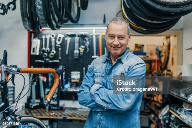 Elegante Meccanico Di Biciclette In Piedi Nella Sua Officina - Fotografie stock e altre immagini di Proprietario