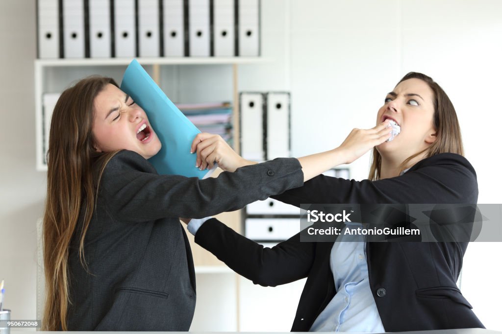 Two angry executives fighting at office Two angry executives fighting hitting with folders at office Arguing Stock Photo