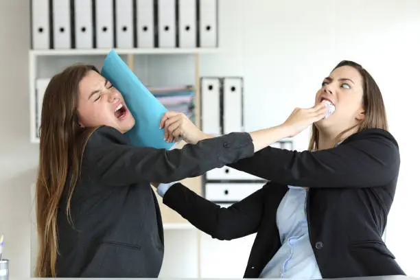 Two angry executives fighting hitting with folders at office