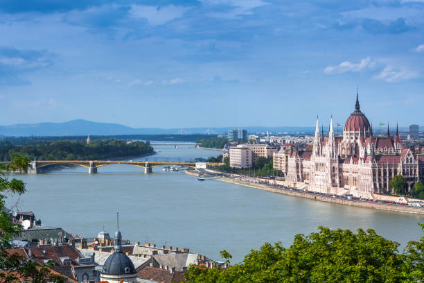 Panoramic cityscape view of hungarian capital city of Budapest from the Gellert Hill. The bridges connecting Buda and Pest across the river Danube. Summertime sunshine day, blue sky and green of trees Panoramic cityscape view of hungarian capital city of Budapest from the Gellert Hill. The bridges connecting Buda and Pest across the river Danube. Summertime sunshine day, blue sky and green of trees budapest danube river cruise hungary stock pictures, royalty-free photos & images