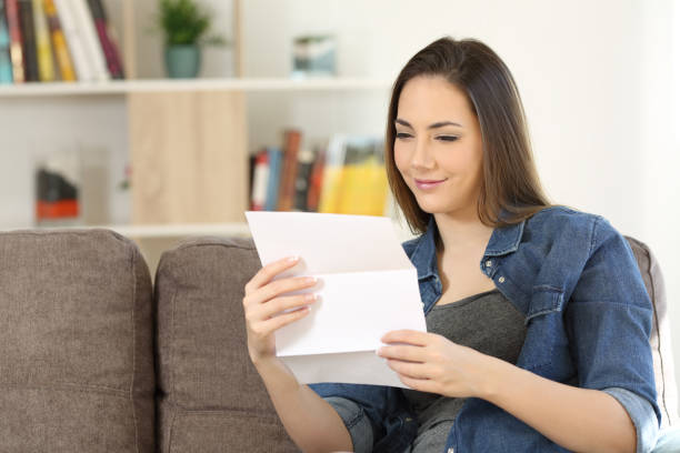 istock Satisfied woman reading a letter at home 950677060