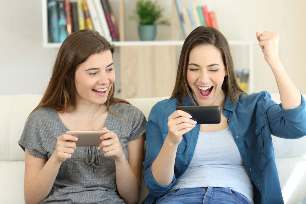 istock Two excited friends playing games and winning 950679492