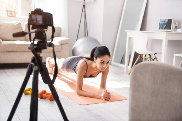 istock Athletic young woman doing a plank exercise and filming herself 950680288