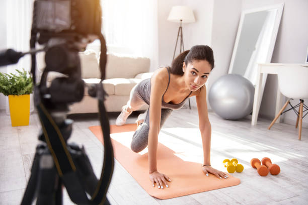 istock Charming woman filming vlog and doing a plank 950680774