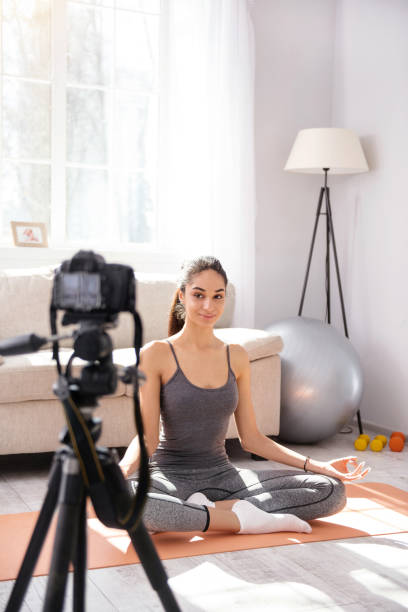 istock Upbeat woman recording herself while practicing yoga 950683390