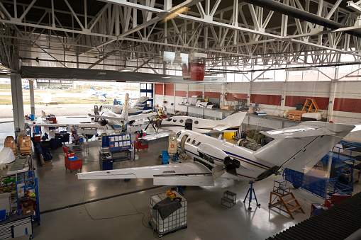 High angle view of private jet aircrafts in the hangar open for regular maintenance service.
