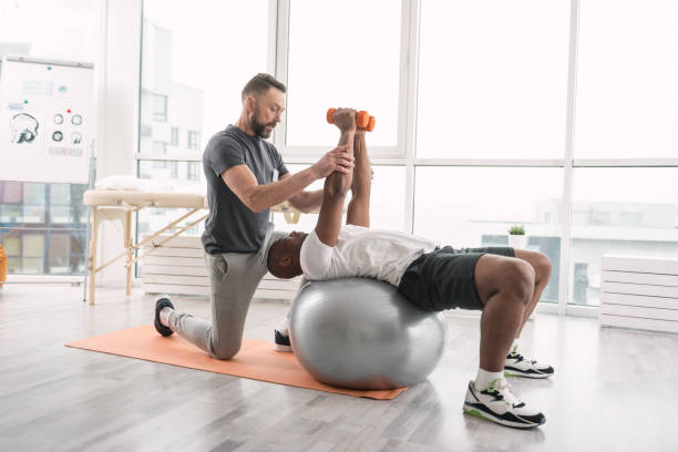 istock Pleasant handsome man lying on the medball 950683674