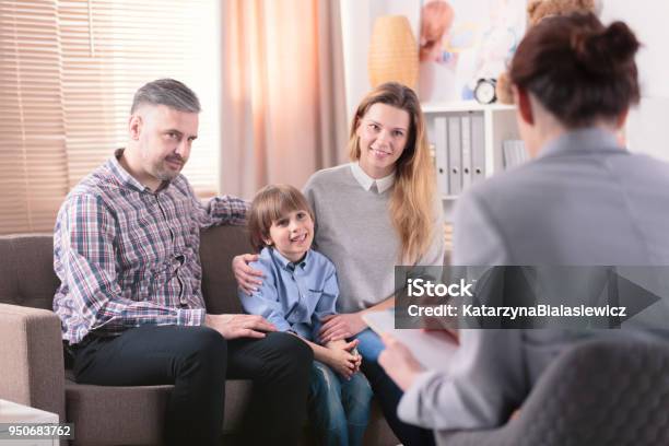 Figlio Sorridente Con Genitori Felici - Fotografie stock e altre immagini di Famiglia - Famiglia, Seduta di terapia, Autismo